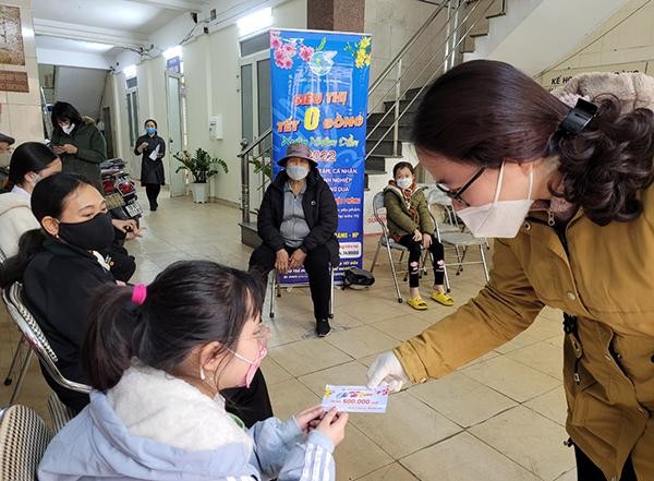 Đại diện Hội Liên hiệp Phụ nữ thành phố Hải Phòng trao tặng phiếu mua hàng tại "Siêu thị Tết 0 đồng". Ảnh: Thu Lê.