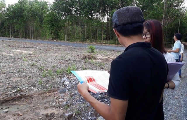 Môi giới dẫn khách hàng đi xem đất.