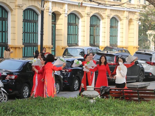 Màu đỏ của tà áo dài cùng với những chiếc nón lá khiến cho phố đi bộ mang một nét đẹp rất thơ mà đã từ rất lâu không xuất hiện. (Ảnh: Phương Linh)