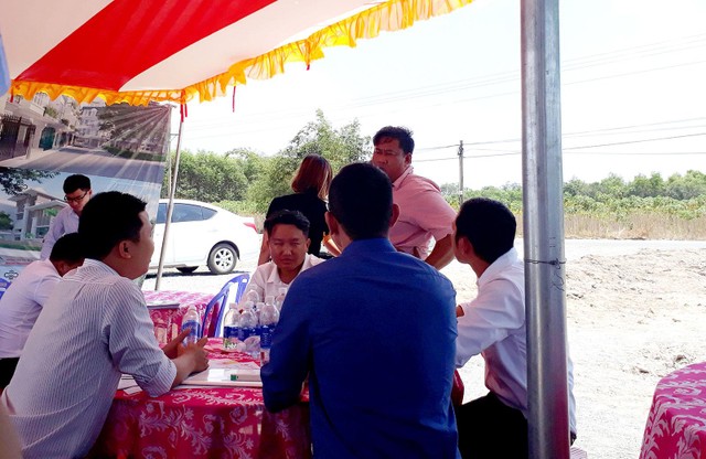 Môi giới tư vấn cho khách hàng xem đất tại Củ Chi. Ảnh: Việt Dũng