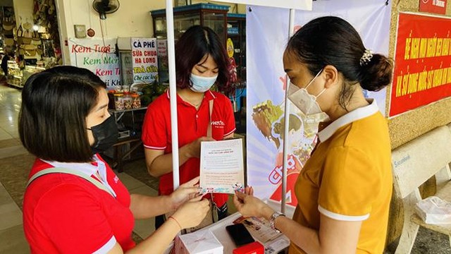 Nhân viên Viettel Quảng Ninh hướng dẫn khách hàng cài đặt ứng dụng Viettel Money để thanh toán không dùng tiền mặt.