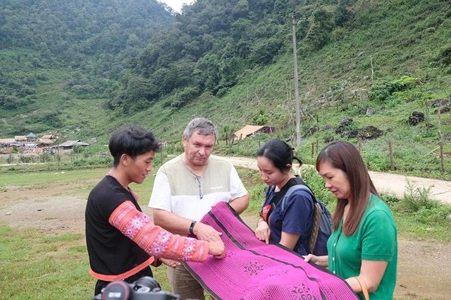 Giàng A La giới thiệu sản phẩm thổ cẩm của đồng bào Mông cho du khách.