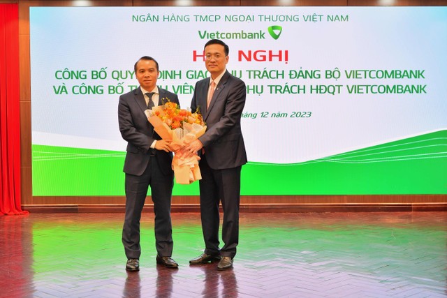 Ông Phạm Quang Dũng - Bí thư Đảng ủy, Chủ tịch HĐQT Vietcombank (bên phải) tặng hoa chúc mừng ông Đỗ Việt Hùng