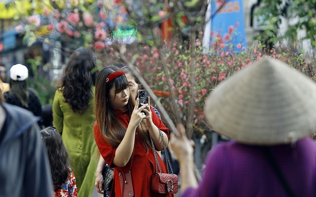 Một cô gái với trang phục áo dài cách tân đang say sưa ghi lại những khoảnh khắc đầy màu sắc của không khí Tết Một cô gái với trang phục áo dài cách tân đang say sưa ghi lại những khoảnh khắc đầy màu sắc của không khí Tết