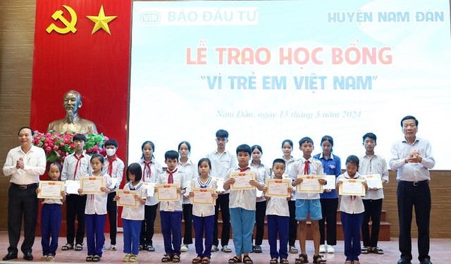 Ông Nguyễn Anh Tuấn, nguyên Tổng Biên tập Báo Đầu tư; Nhà sáng lập Học bổng Vì trẻ em Việt Nam và ông Vương Hồng Thái, Uỷ viên Ban thường vụ Huyện uỷ trao học bổng và giấy chứng nhận cho các em học sinh.