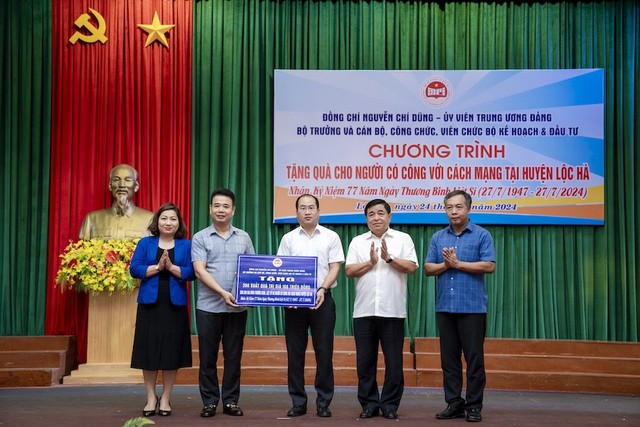 Bộ trưởng Nguyễn Chí Dũng, Chủ tịch Công đoàn Bộ Lê Thị Tường Thu, Tổng biên tập Báo Đầu tư Lê Trọng Minh trao quà cho các gia đình người có công tại huyện Lộc Hà, Hà Tĩnh. Ảnh: Trường Sơn