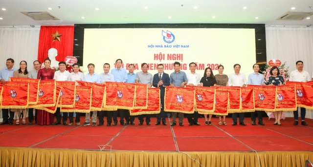 Chủ tịch Hội Nhà báo Việt Nam Lê Quốc Minh trao tặng Cờ thi đua của Hội cho 21 tập thể có thành tích xuất sắc. Ảnh: Sơn Hải. Chủ tịch Hội Nhà báo Việt Nam Lê Quốc Minh trao tặng Cờ thi đua của Hội cho 21 tập thể có thành tích xuất sắc. Ảnh: Sơn Hải.