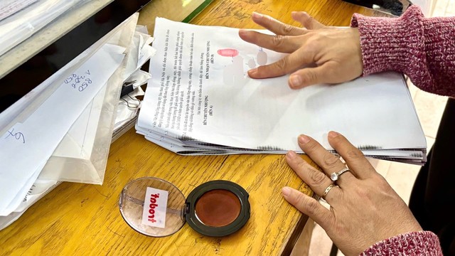 Người dân điểm chỉ trong hợp đồng công chứng nhà đất. Ảnh: Thanh Vũ.