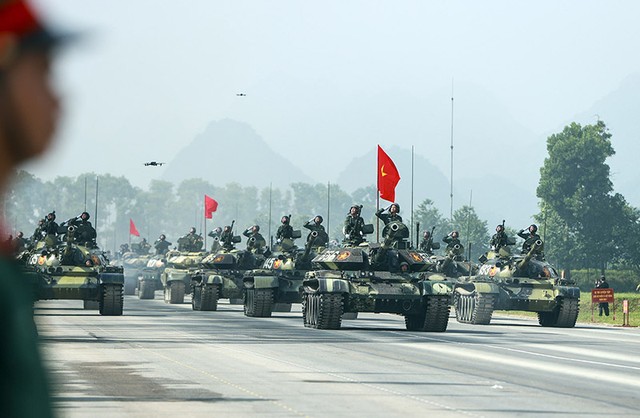 Khối xe pháo quân sự trên đường hành tiến, dẫn đầu là khối xe tăng, đây là những khí tài hiện đại, ưu điểm hỏa lực mạnh, tính cơ động cao.