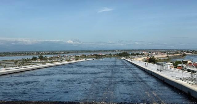Nhà thầu đang triển khai thảm nhựa phần đầu cầu Thuận An phía bờ nam.