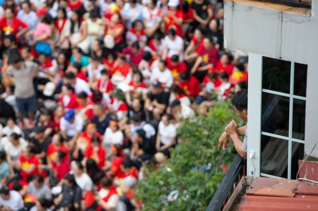 Trên phố Cửa Nam, nơi có không gian khá thoáng và rộng, nhưng nhiều người vẫn không thể tìm được một chỗ ngồi đành chọn vị trí trên cao, có thể bao quát nhưng khá xa vị trí di chuyển của các đoàn. Ảnh: Minh Hà