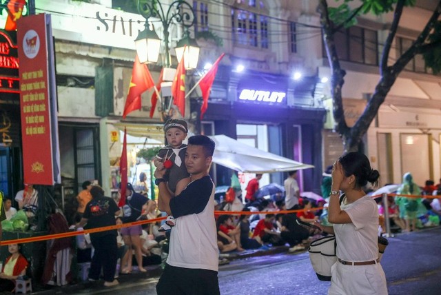 Một gia đình trẻ cho con đi tận hưởng không khí của ngày đại lễ.