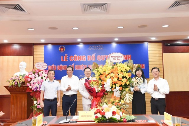 Đại diện Đảng ủy Bộ Tài chính tặng hoa chúc mừng ông Nguyễn Thành Hưng.