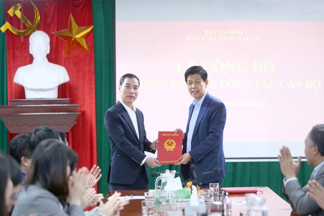 Thừa ủy quyền của Bộ trưởng Bộ Tài chính, Tổng Biên tập Báo Tài chính - Đầu tư Phạm Văn Hoành (bên phải) trao quyết định điều động, bổ nhiệm Phó Tổng Biên tập Báo Tài chính - Đầu tư cho ông Ngô Chí Tùng. Ảnh: Đức Minh