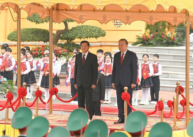 Tổng Bí thư Tô Lâm và Tổng Bí thư, Chủ tịch nước Lào Thongloun Sisoulith trên bục danh dự, thực hiện nghi thức chào cờ - Ảnh: VGP/Nhật Bắc