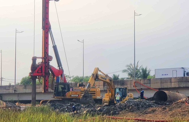 Một bên là dòng xe lưu thông đông đúc, một bên là công trường thi công kéo dài theo hành lang tuyến.