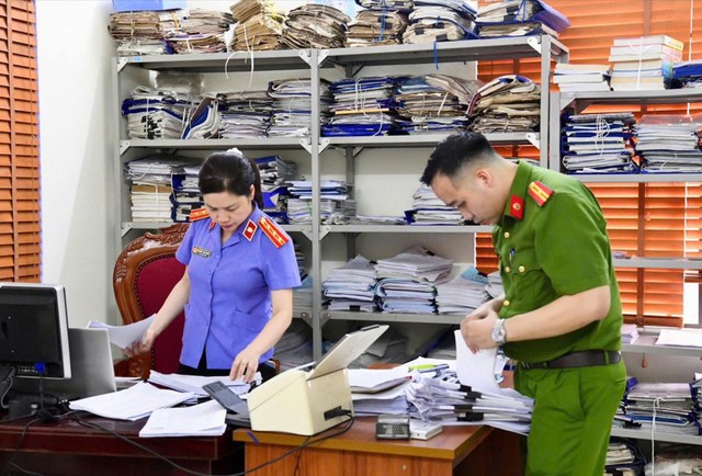 Lực lượng chức năng khám xét, thu giữ nhiều hồ sơ, chứng cứ liên quan tới vụ án. Lực lượng chức năng khám xét, thu giữ nhiều hồ sơ, chứng cứ liên quan tới vụ án.