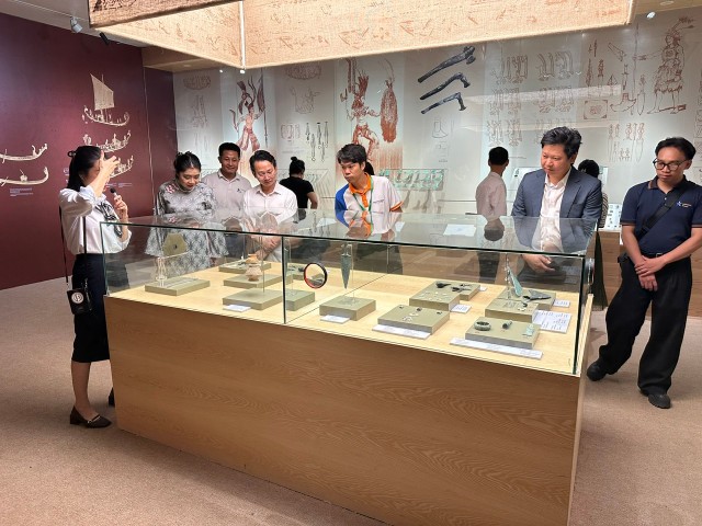 Đoàn xem hiện vật tại khu trưng bày "Vườn Chuối". Ảnh: Hoàng Quyên.