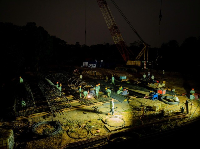 Trên công trường, các công nhân làm việc 3 ca, cả ngày lẫn đêm, nhiều máy móc, xà lan hoạt động liên tục. Trên công trường, các công nhân làm việc 3 ca, cả ngày lẫn đêm, nhiều máy móc, xà lan hoạt động liên tục.