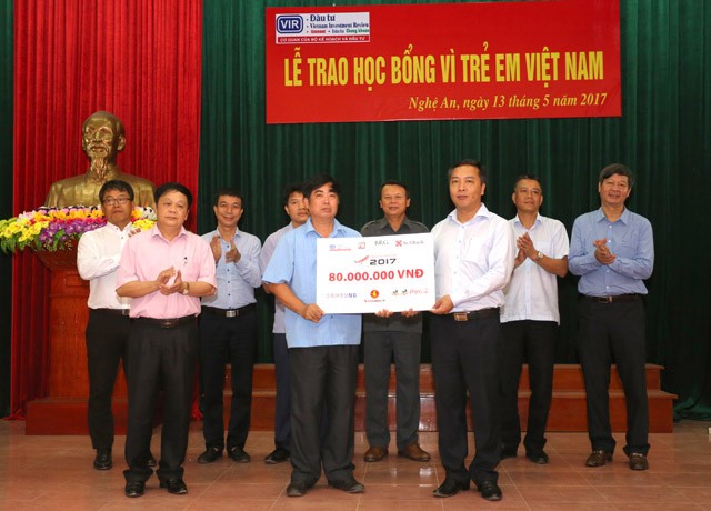 Ông Lê Trọng Minh (hàng đầu, bên phải) – Tổng biên tập Báo Đầu tư trao tấm biển tượng trưng 160 suất học bổng Giải golf Báo Đầu tư cho Lãnh đạo huyện Nam Đàn, tỉnh Nghệ An trước sự chứng kiến của Đảng ủy Bộ Kế hoạch và Đầu tư, Cục A84 Bộ Công An và các đơn vị tài trợ.