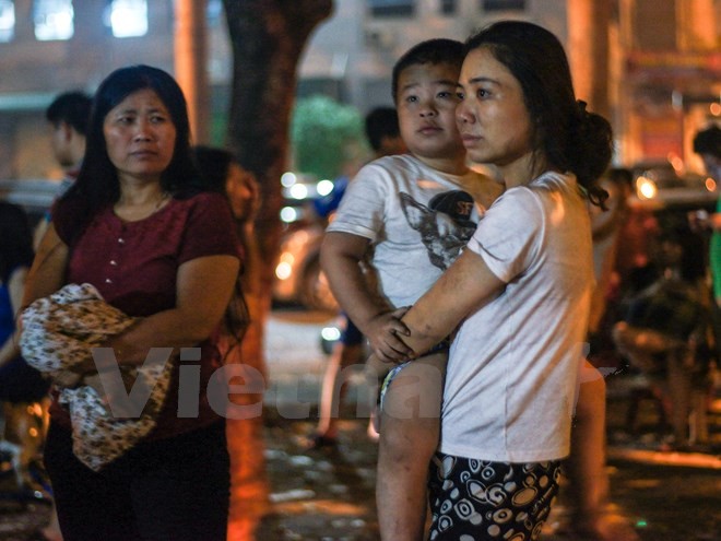 Nhiều em nhỏ ngơ ngác khi đang ngủ ngon nhưng lúc tỉnh dậy lại thấy đang ở ngoài đường trong cảnh hỗn loạn. (Ảnh: PV/Vietnam+)