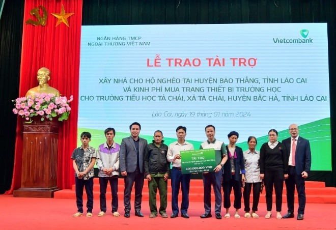 Ông Lê Hoàng Tùng - Phó tổng giám đốc Vietcombank (thứ 5 từ phải sang) cùng ông Đặng Việt Hùng – Bí thư Chi bộ, Giám đốc Vietcombank Lào Cai (ngoài cùng bên phải) trao biểu trưng số tiền 300 triệu đồng cho 6 hộ gia đình khó khăn tại huyện Bảo Thắng.