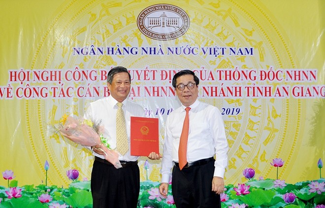 Phó Thống đốc NHNNVN Nguyễn Kim Anh trao quyết định và chúc mừng ông Nguyễn Tuấn Dũng.