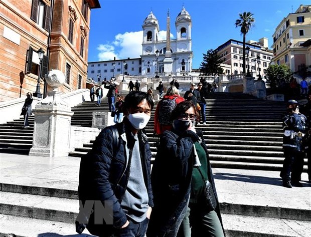 Người dân và du khách đeo khẩu trang phòng lây nhiễm COVID-19 tại Venice, Italy, ngày 8/3. (Ảnh: AFP/TTXVN)