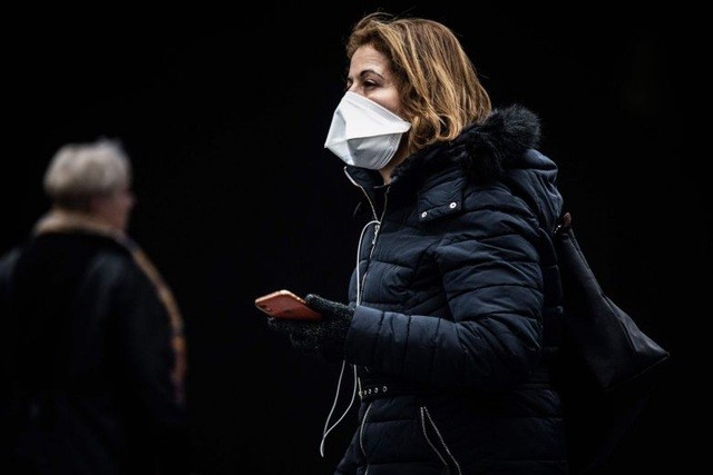 Một phụ nữ đeo khẩu trang tại một ga tàu ở Paris (Ảnh: AFP).