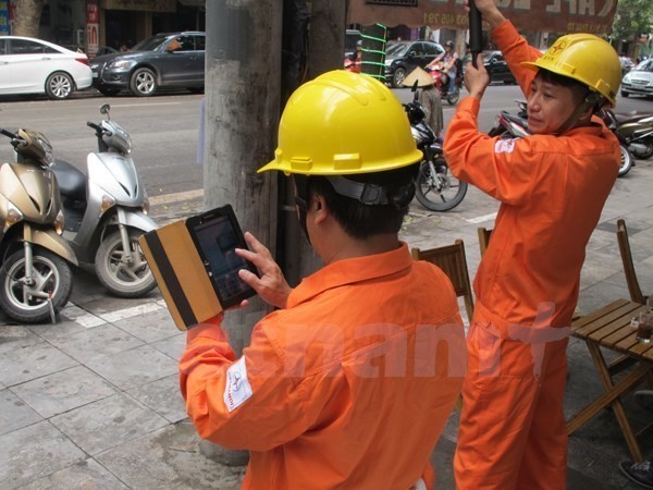 Nhân viên ngành điện ghi chỉ số côngtơ của khách hàng. (Nguồn: Đức Duy/Vietnam+).