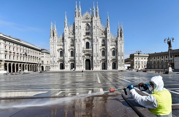 Nhân viên y tế Italy khử khuẩn nơi công cộng. (Ảnh: CNBC).