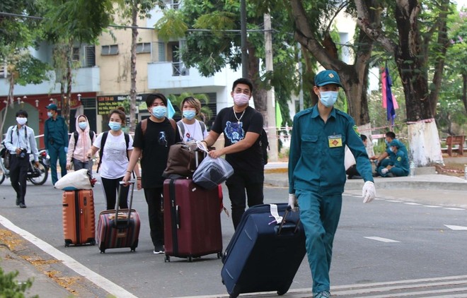 Lực lượng dân quân tự vệ Thành phố hỗ trợ người cách ly trở về nhà sau khi hoàn thành cách ly 14 ngày. (Ảnh: Thanh Vũ/TTXVN).