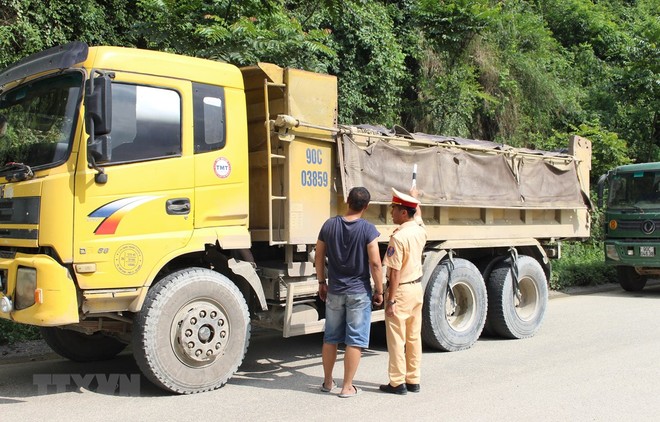 Cảnh sát giao thông kiểm tra một xe tải lưu thông trên đường. Ảnh minh họa. (Nguồn: TTXVN).