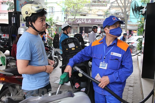 Nhân viên Petrolimex đang bán xăng cho khách hàng. (Ảnh: Đức Duy/Vietnam+).