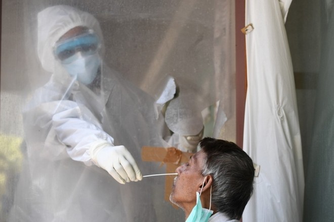 Nhân viên y tế lấy mẫu xét nghiệm cho người dân ở New Delhi, Ấn Độ, hôm 16/6. Ảnh: AFP.