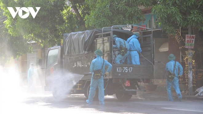 Lực lượng chức năng phun hóa chất khử khuẩn tại phường Hưng Dũng nơi phát hiện ca mắc Covid-19.