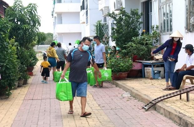 Chuyển nhu yếu phẩm đến cho người dân đang cách ly tại khu C, chung cư Văn Thánh, phường Phú Tài, thành phố Phan Thiết. (Ảnh: Nguyễn Thanh/TTXVN).