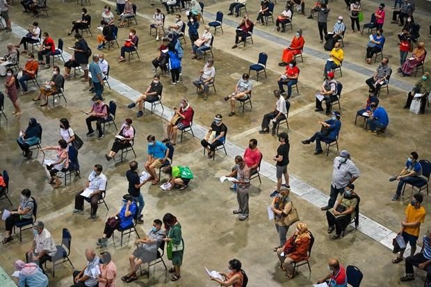 Người dân xếp hàng chờ tiêm vaccine phòng COVID-19 tại Kuala Lumpur, Malaysia. (Ảnh: AFP/TTXVN)