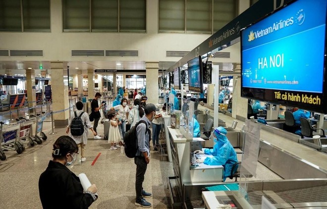 Hành khách Vietnam Airlines làm thủ tục ở quầy check-in sân bay Tân Sơn Nhất. (Ảnh: CTV/Vietnam+).