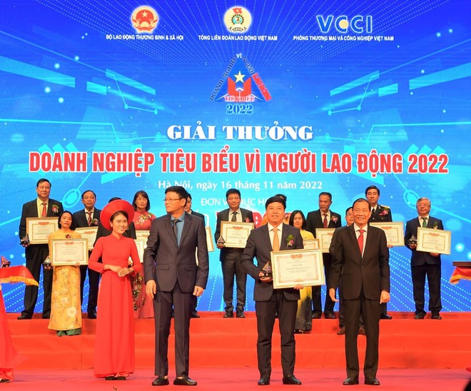 Đ/c Hoàng Quang Phòng - Phó Chủ tịch VCCI (bên phải) trao Bằng khen “Doanh nghiệp tiêu biểu vì người lao động” của VCCI và đ/c Nguyễn Ngọc Hiển - Ủy viên Đoàn Chủ tịch Tổng Liên đoàn Lao động Việt Nam, Tổng biên tập báo Lao Động (bên trái) tặng Kỷ niệm chương cho ông Hồng Quang - Thành viên HĐQT kiêm Giám đốc Khối Nhân sự, Chủ tịch Công đoàn Vietcombank - đại diện Vietcombank.