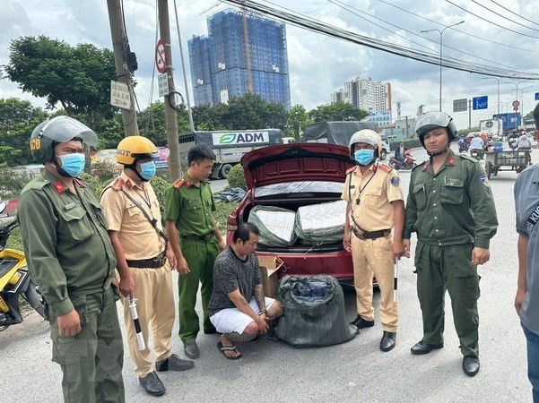 Lực lượng chức năng, Công an thành phố Dĩ An, tỉnh Bình Dương, bắt quả tang đối tượng Võ Đức Quốc Trung vận chuyển cung cấp thuốc lá lậu. (Ảnh: TTXVN phát)