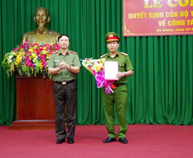 Thiếu tướng Bùi Minh Giám, Phó Tổng cục trưởng Tổng cục chính trị Công an nhân dân trao quyết định và tặng hoa chúc mừng Thượng tá  Lục Thế Hưng, tân phó giám đốc Công an tỉnh Hà Giang