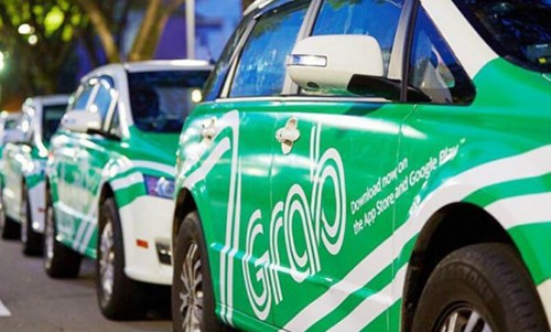 Taxi công nghệ Grab di chuyển trên đường phố.