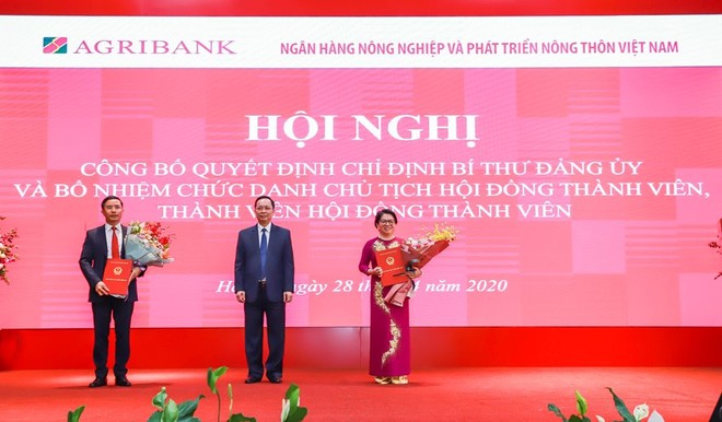 Phó Thống đốc Đào Minh Tú (đứng giữa) trao quyết định cho ông Phạm Đức Ấn (bên tay trái) và bà Đỗ Thị Nhàn (bên tay phải)