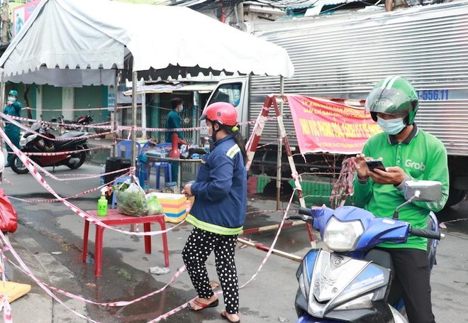 Hiện nhiều người dân thuộc khu vực phong toả nhưng không thuộc diện phải cách ly tại nhà đã có thể ra trạm kiểm soát Bùi Văn Ba nhận hàng hoá (Ảnh: Thị Hồng).