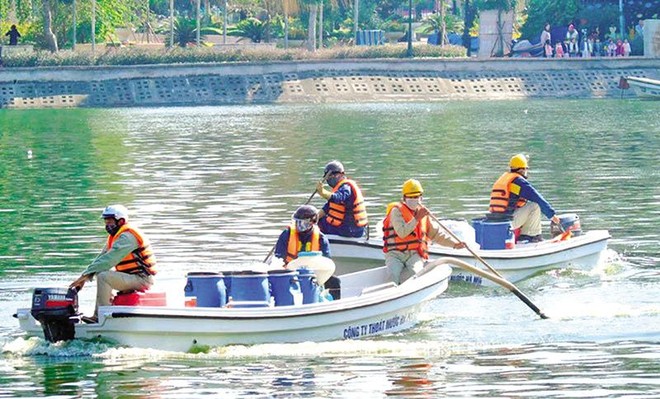 Vừa chỉ đạo miệng trái với văn bản giúp công ty của vợ hưởng lợi hàng chục tỷ đồng trong vụ mua chế phẩm Redoxy 3C, ông Chung vừa chủ động yêu cầu thanh tra, rồi ép buộc Thanh tra TP. Hà Nội thay đổi kết luận theo hướng không có sai phạm. Trong ảnh: Nhân viên Công ty Thoát nước Hà Nội dùng chế phẩm Redoxy 3C xử lý ô nhiễm nước hồ tại Hà Nội. Ảnh: H.N