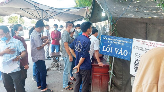 Cảnh đoàn người và xe xếp hàng dài chờ làm thủ tục tại chốt kiểm soát dịch ở Quốc lộ 13 vào tỉnh Bình Phước. Ảnh: Việt Dũng