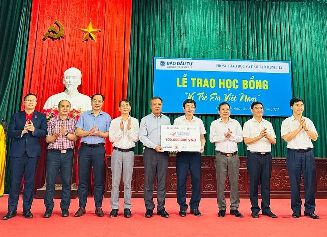 Tổng Biên tập Báo Đầu tư Lê Trọng Minh (thứ năm từ trái qua) trao biểu trưng 100 triệu đồng cho đồng chí Nguyễn Tiến Hoạt, Trưởng phòng Giáo dục huyện Hưng Hà, với sự chứng kiến của đồng chí Trần Hữu Nam, Tỉnh ủy viên, Bí thư Huyện ủy; đồng chí Nguyễn Trọng Lộ, Phó Bí thư thường trực Huyện ủy, Chủ tịch HĐND huyện; đồng chí Đinh Bá Khải, Phó chủ tịch UBND huyện.