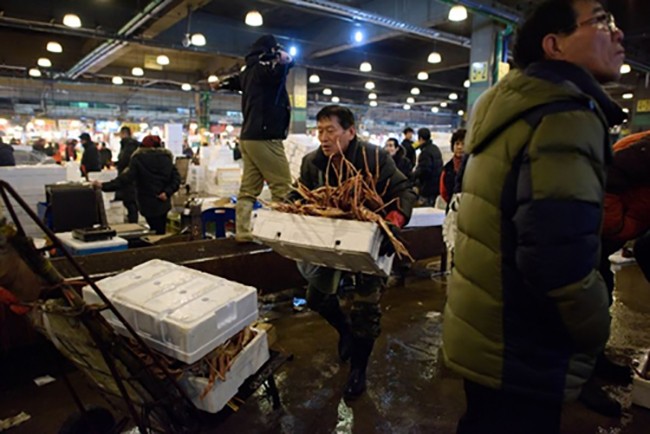 Một tiểu thương với thùng cua ở chợ cá Noryangjin, Seoul. Ảnh: AFP