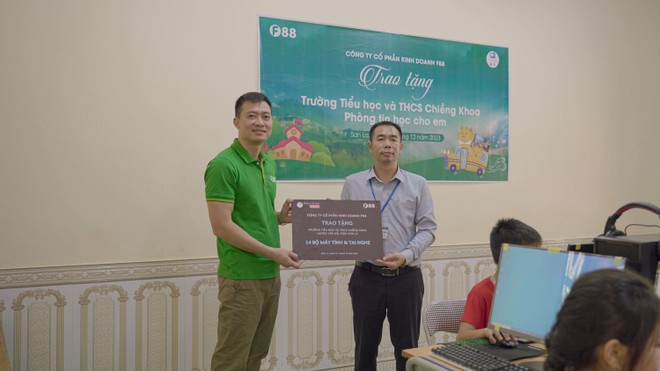 Thầy hiệu trưởng Vũ Hồng Trường đại diện trường Tiểu học và Trung học cơ sở Chiềng Khoa nhận món quà là phòng tin học do Công ty Cổ phần Kinh doanh F88 trao tặng